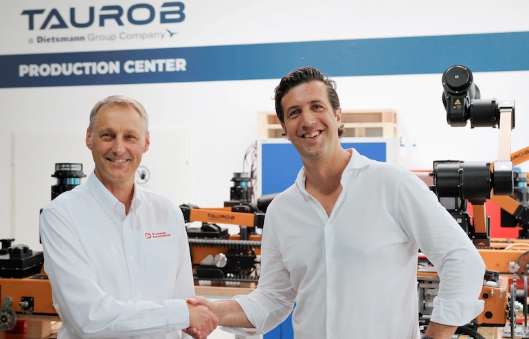 Taurob and Rockwell Automation executives shake hands marking their partnership.