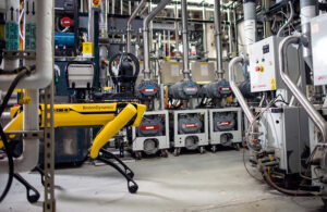 boston dynamics spot quadruped walks through a facility.