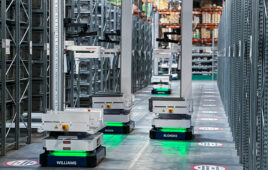 Three Brightpick Autopickers in an aisle in a warehouse.