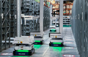 Three Brightpick Autopickers in an aisle in a warehouse.