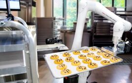 A CRX-20iA/L robot from FANUC sliding a tray of cookies onto a rack.