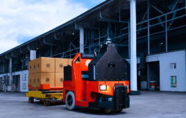 a mobile robot navigating outdoors near a warehouse.