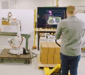 A human working near an industrial robot arm from ABB, thanks to Veo Robotics' FreeMove.