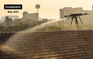 an aerial drone spraying liquid onto a roof