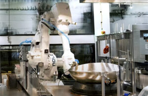 Nala Robotics new BIRYANIMAN holding a silver bowl in a kitchen.