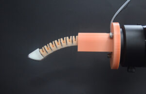 The researchers' robotic finger, which looks like a skinny, ribbed finger with an orange base.