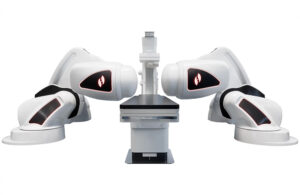 The Stereotaxis Genesis RMN, which features two large, white robotic arms with magnets on each end, sitting in between the arms is a table.